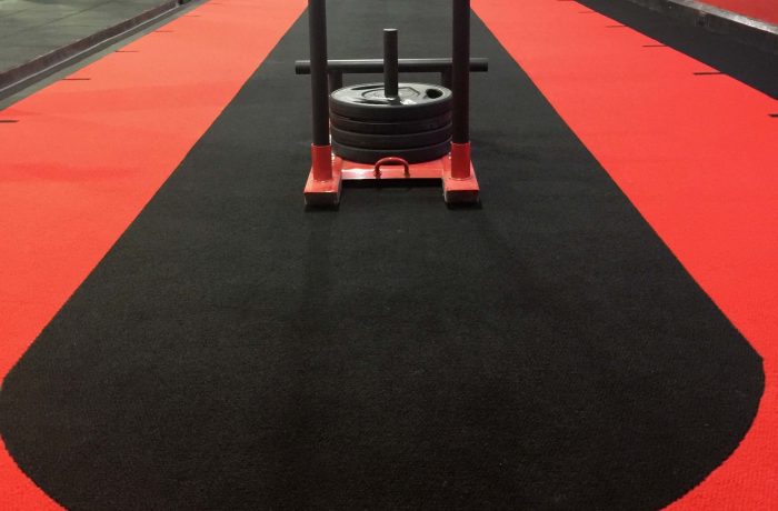 Weighted sled on the red and black sprint track