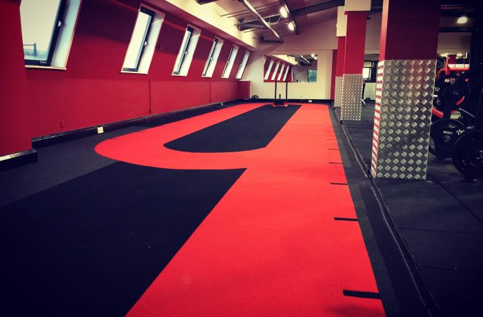 Red and black sprint track alongside the strength training floor