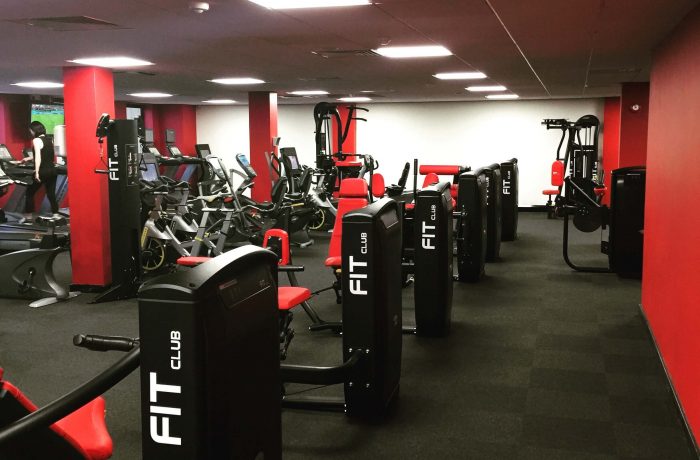 Rows of resistance machines on the Fit Club gym floor