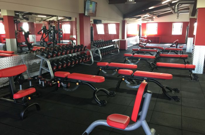 Mirrored dumbbell area with red adjustable benches