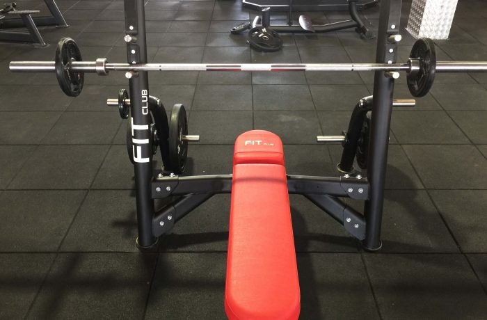 Bench press station with a racked barbell